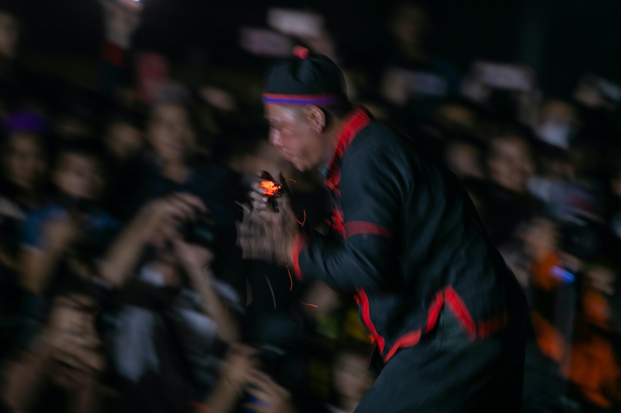 Nghệ nhân biểu diễn cầm than chạy xung quanh khu vực biểu diễn. Ảnh: Minh Dân