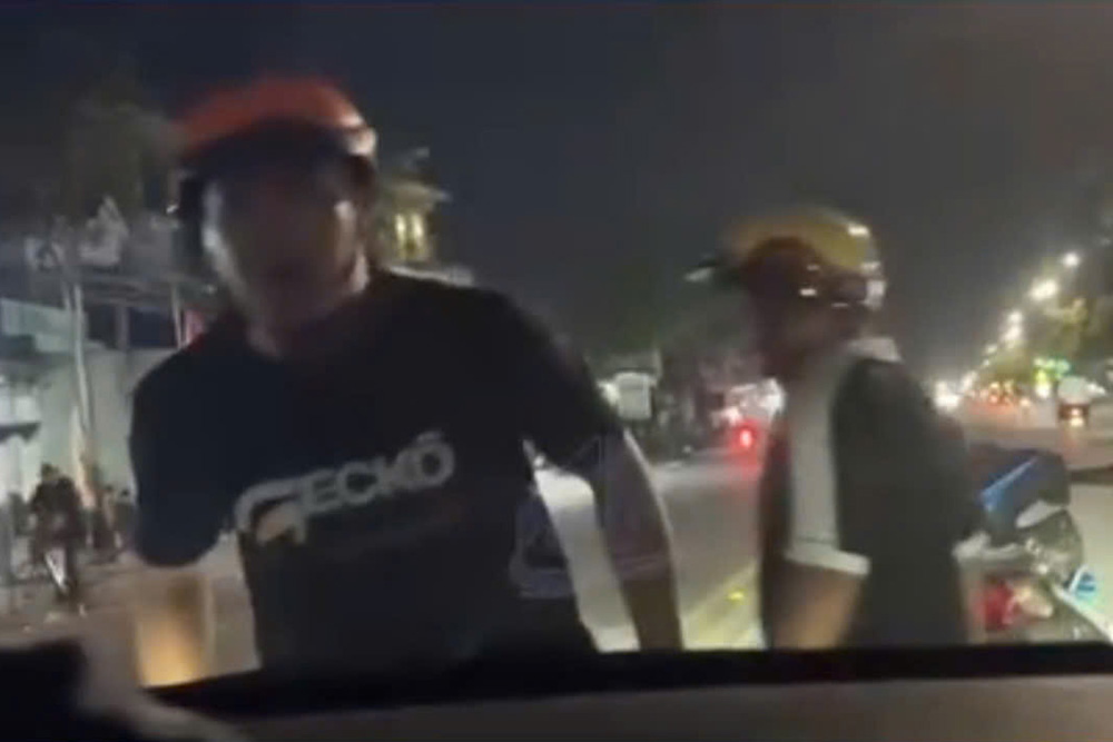 Hình ảnh hai thanh niên chặn đầu xe taxi sau va chạm giao thông ở Tây Ninh. Ảnh: Cắt từ video