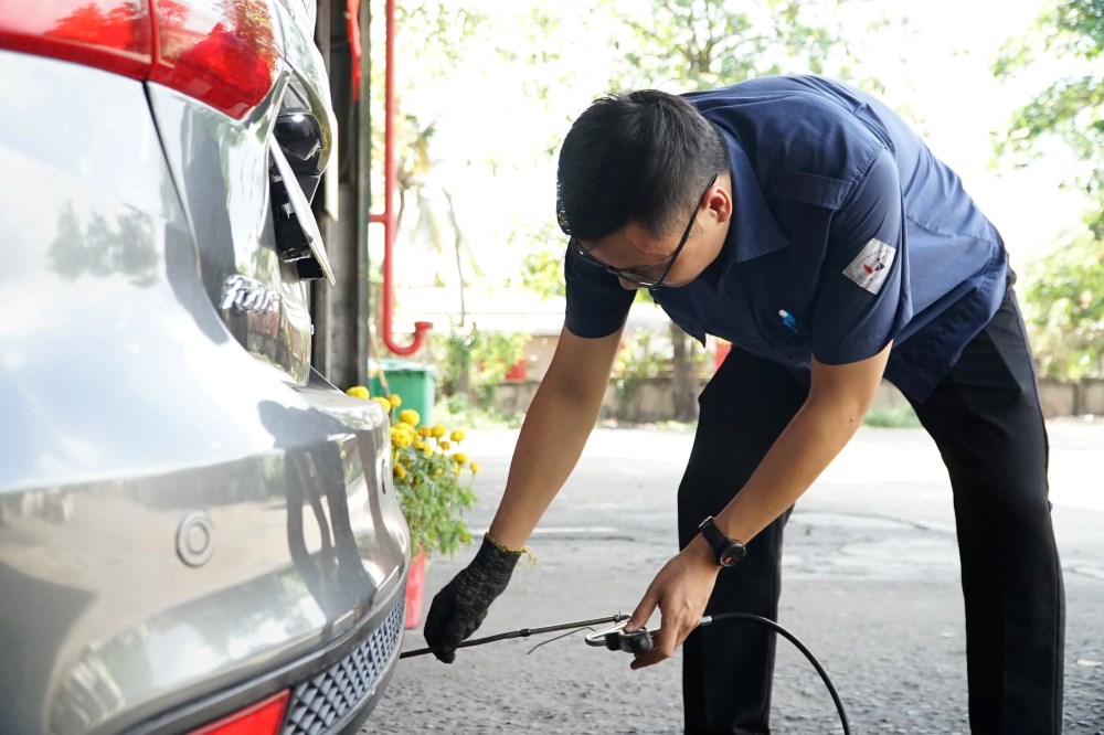 Kỹ thuật viên thao tác đo khí thải ô tô chạy xăng theo quy trình mới, bắt buộc đo ở cả tốc độ không tải thấp và cao. Ảnh: Anh Tú