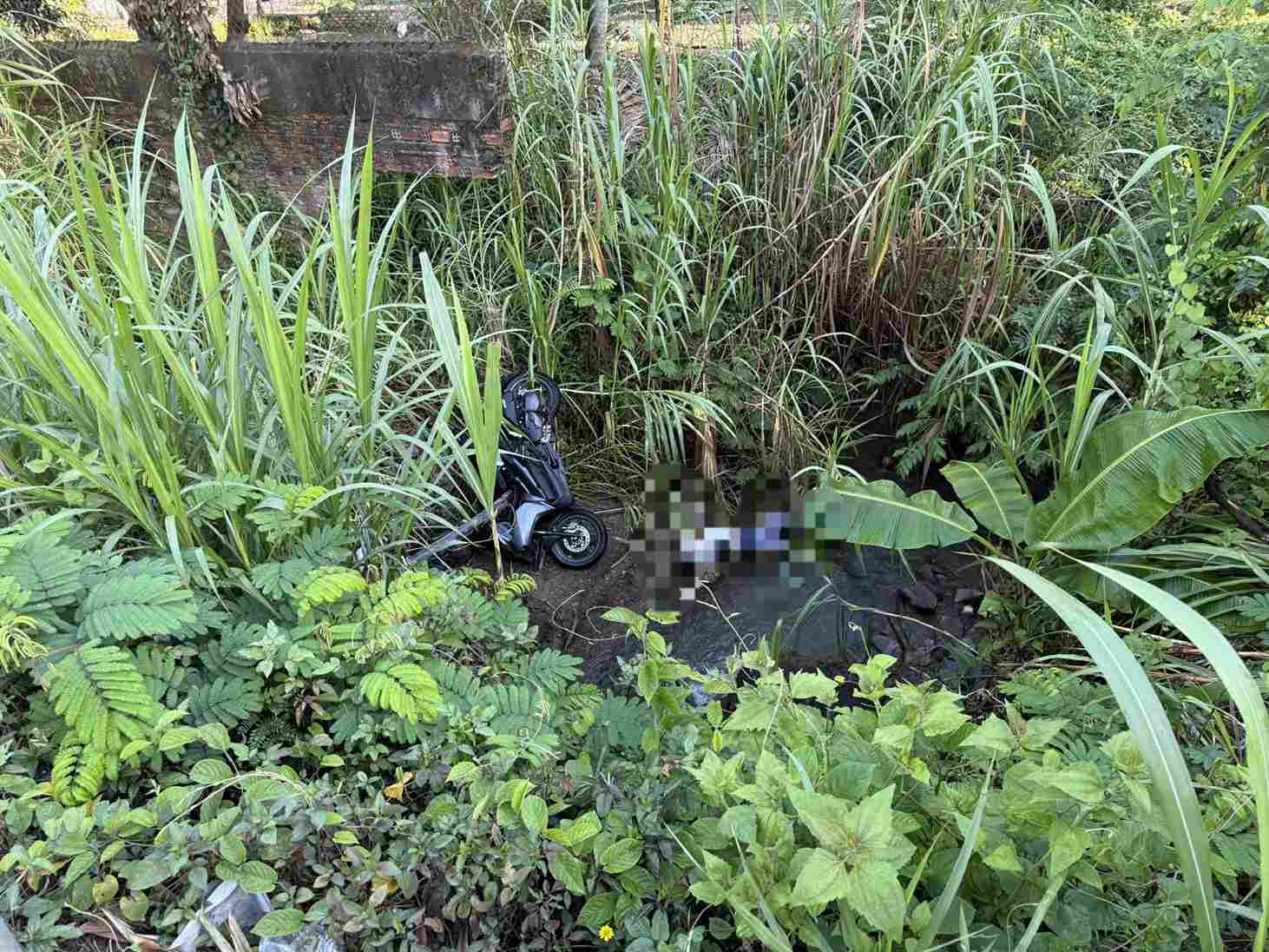 Thi thể nam sinh viên cùng xe máy nằm dưới vực sâu khoảng 4 mét tại chân đèo Chuối (xã Đạ Huoai). Ảnh: Trọng Đại 