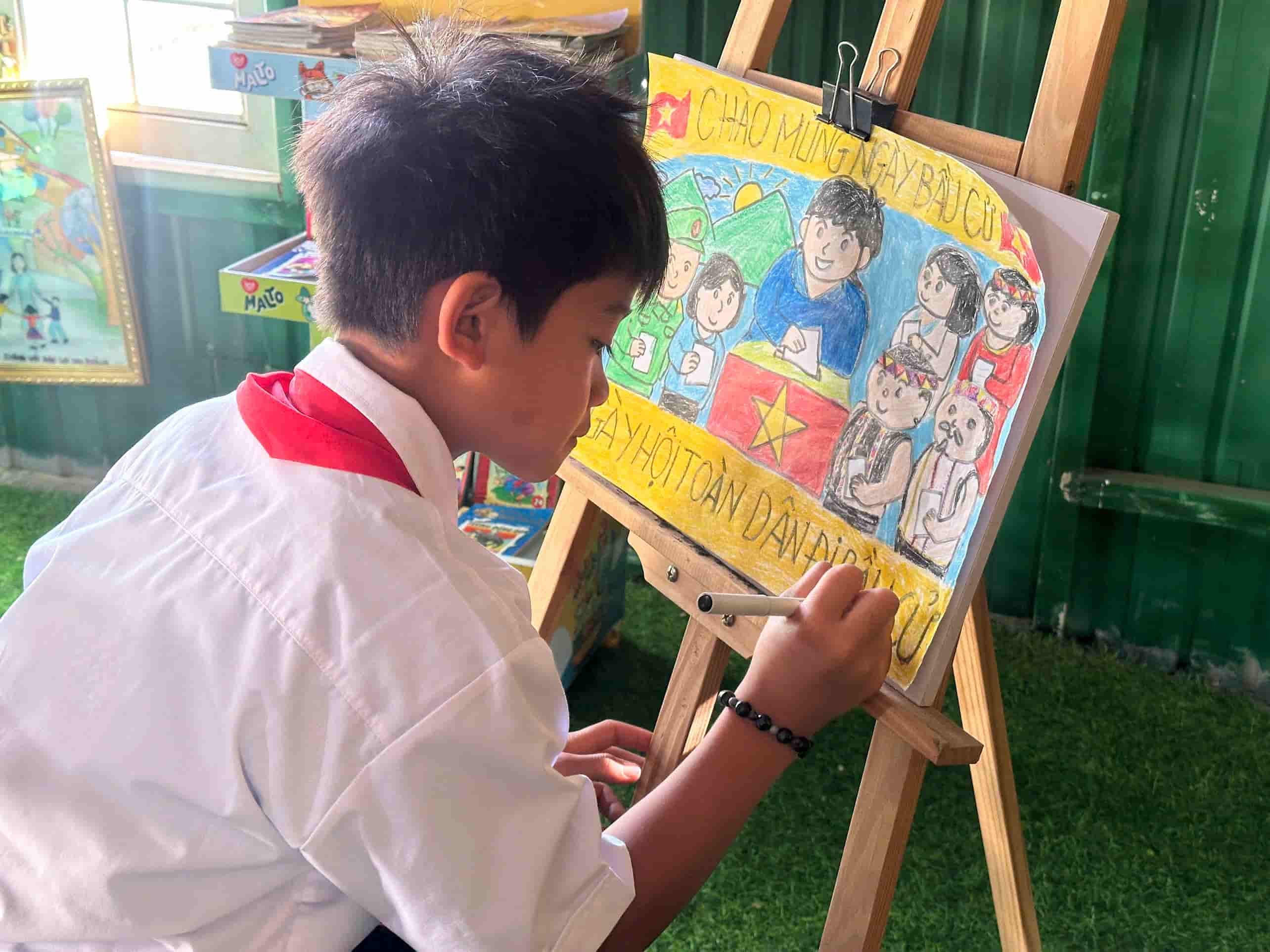 Des élèves des régions montagneuses peignent des tableaux en réponse aux élections. Photo: Mạnh Võ