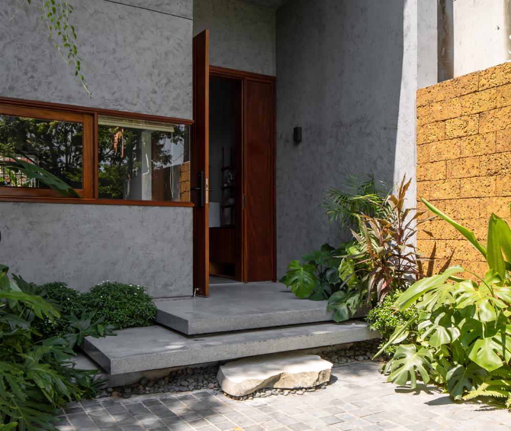 Những mảng tường đặc kết hợp khoảng lùi cây xanh giúp hạn chế tác động của hướng nắng Tây Nam, cũng như giảm thiểu tối đa lượng khói bụi và tiếng ồn từ bên ngoài vào. 