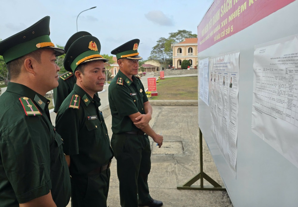 Cán bộ, chiến sĩ nghiên cứu danh sách, tiểu sử các ứng cử viên đại biểu Quốc hội khóa XVI và đại biểu HĐND các cấp nhiệm kỳ 2026–2031 được niêm yết tại khu vực đơn vị. Ảnh: Tuấn Kiệt