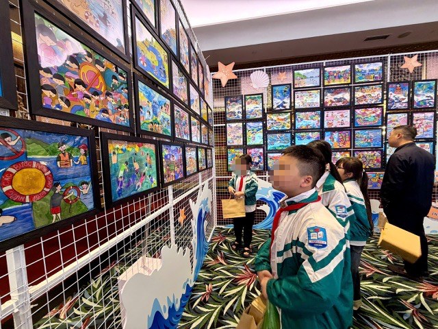 Students visit paintings on the theme of drowning prevention. Photo: Duc Van