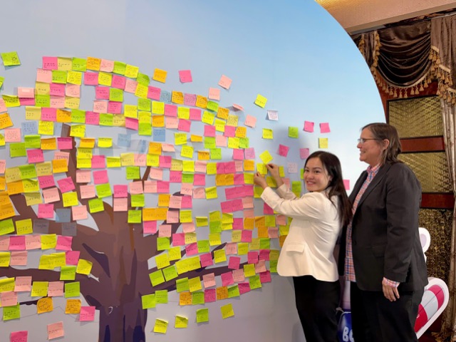 Bà Đoàn Thu Huyền (áo trắng) dán thông điệp phòng chống đuối nước. Ảnh: Đức Vân