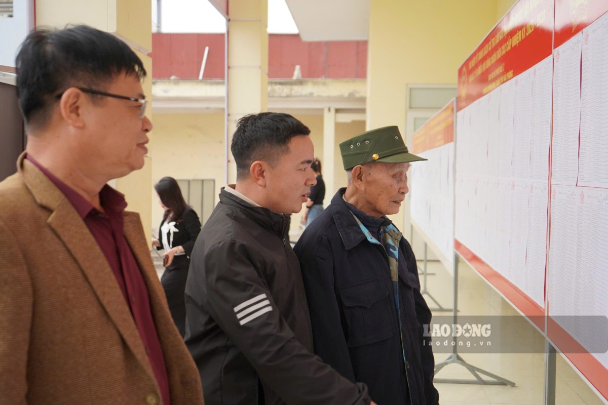 Mr. Ngo Van Sinh finds his family name in the voter list posted at polling station No. 2, Duong Kinh ward. Photo: Mai Dung