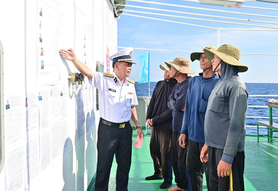 Đại tá Lê Hồng Quang, giới thiệu và hướng dẫn cho cử tri trên tàu cá QNg96435TS của Quảng Ngãi. Ảnh: Văn Đường