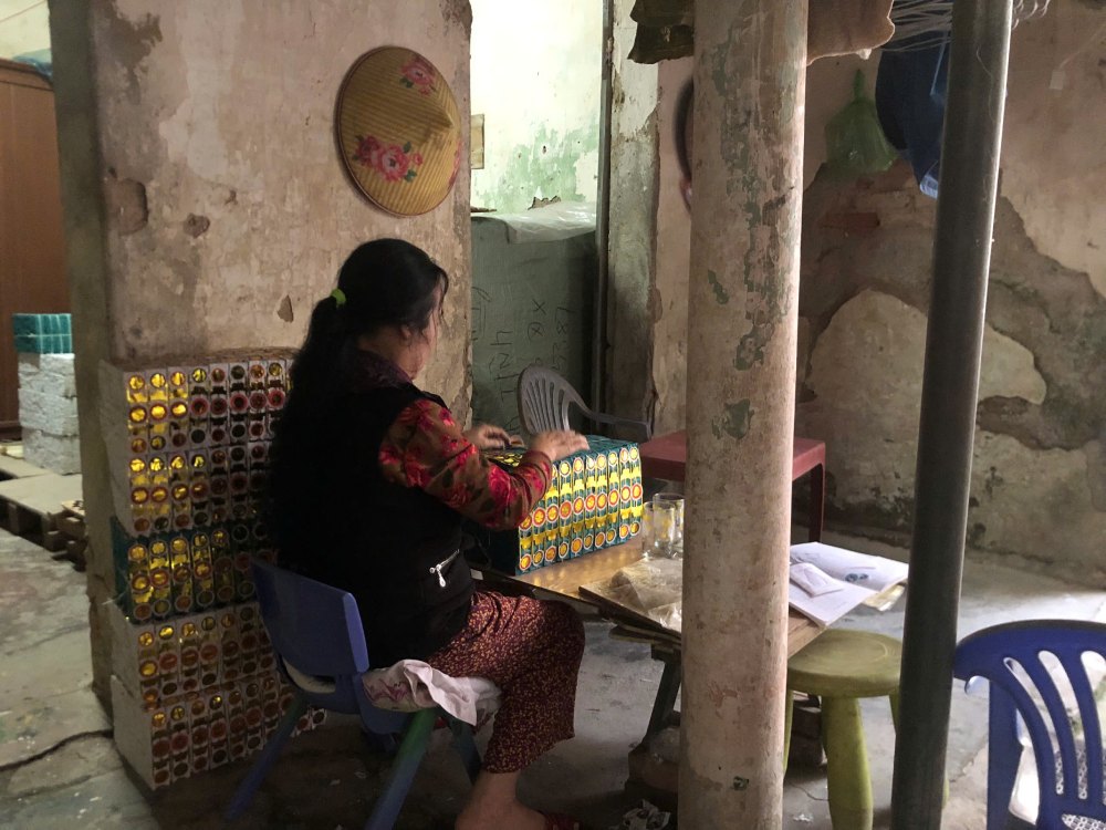 Bà Son dù bệnh tật vẫn cố gắng đan hoa phụ giúp gia đình, nuôi nấng 2 cháu. Ảnh: Quỳnh Chi