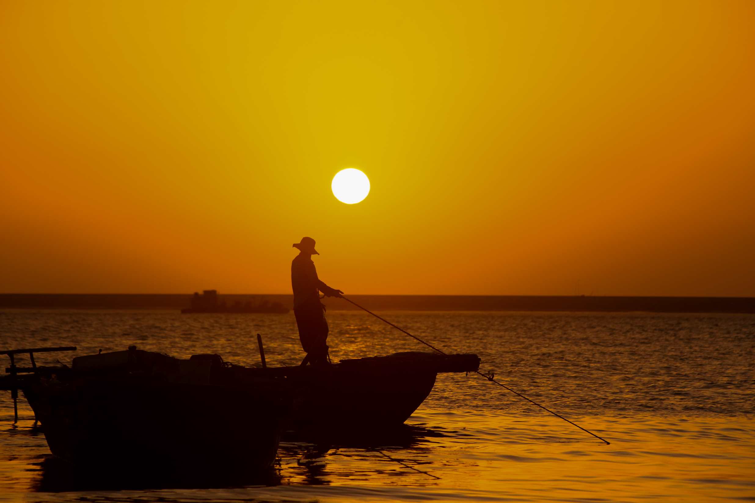 ในแสงยามบ่ายคล้อย ชาวประมงต่างตั้งใจดึงอวนสุดท้ายของวันขึ้นมาอย่างขะมักเขม้น