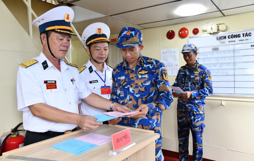 Cử tri nhận phiếu bầu cử trên tàu. Ảnh: Mạnh Kiên