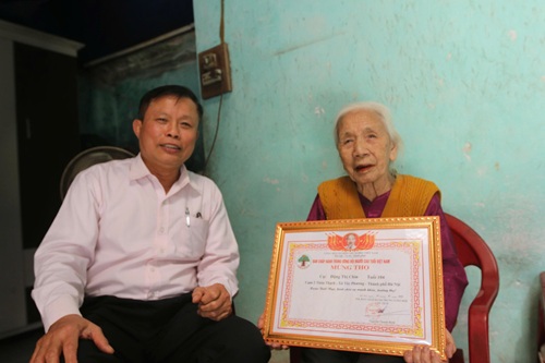 Village Party Secretary, Head of Thach village election team Mr. Phung Khac De next to Mrs. Dang Thi Chin, 104 years old. Photo: Minh Hanh