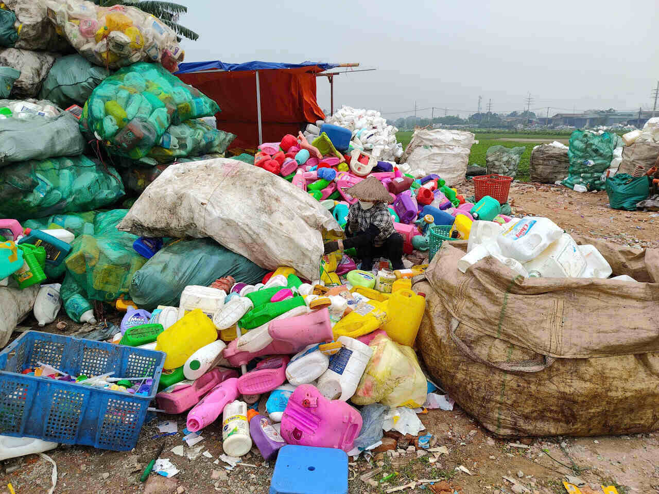 Hoạt động tái chế rác thải nhựa mang lại nguồn sinh kế cho hàng nghìn người dân thôn Xà Cầu, nhưng cũng gây nguy hại cho sức khỏe của họ và cộng đồng xung quanh. Ảnh: Viên Nguyễn