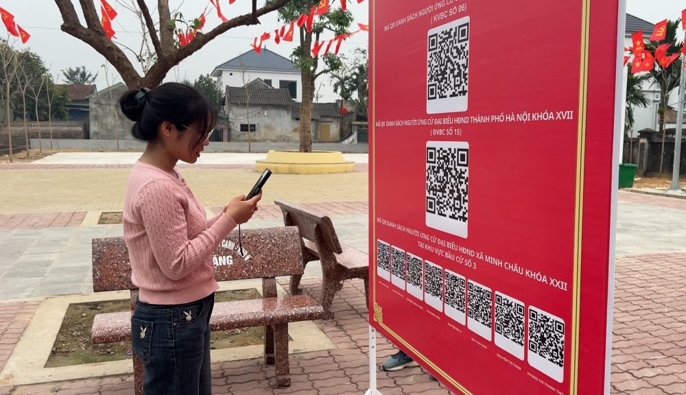 Voters in Minh Chau island commune, Hanoi City scan QR codes to find out the list of candidates that have been digitized.