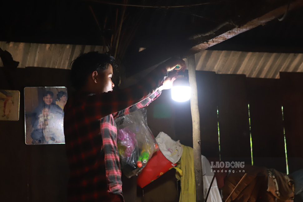 Anh Đinh Văn Hiệp chỉnh lại bóng đèn leo lét trong căn nhà nhỏ. Ảnh: Hoài Phương