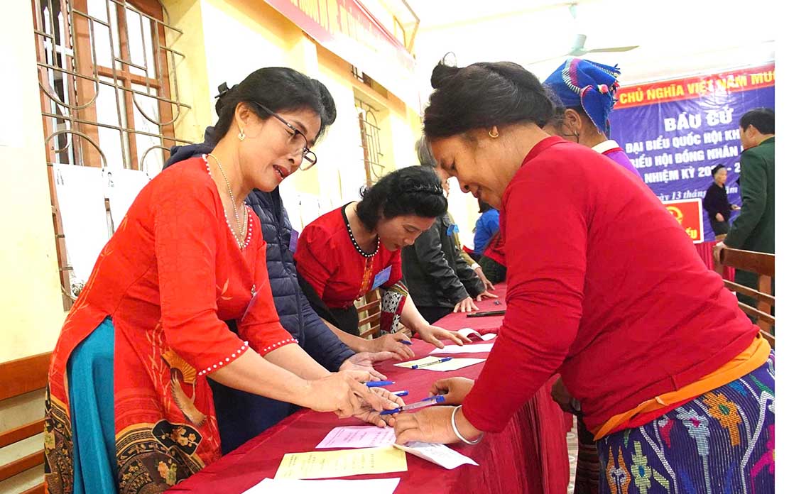 Cán bộ tổ bầu cử hướng dẫn cử tri thủ tục bầu cử. Ảnh: Quang Đại
