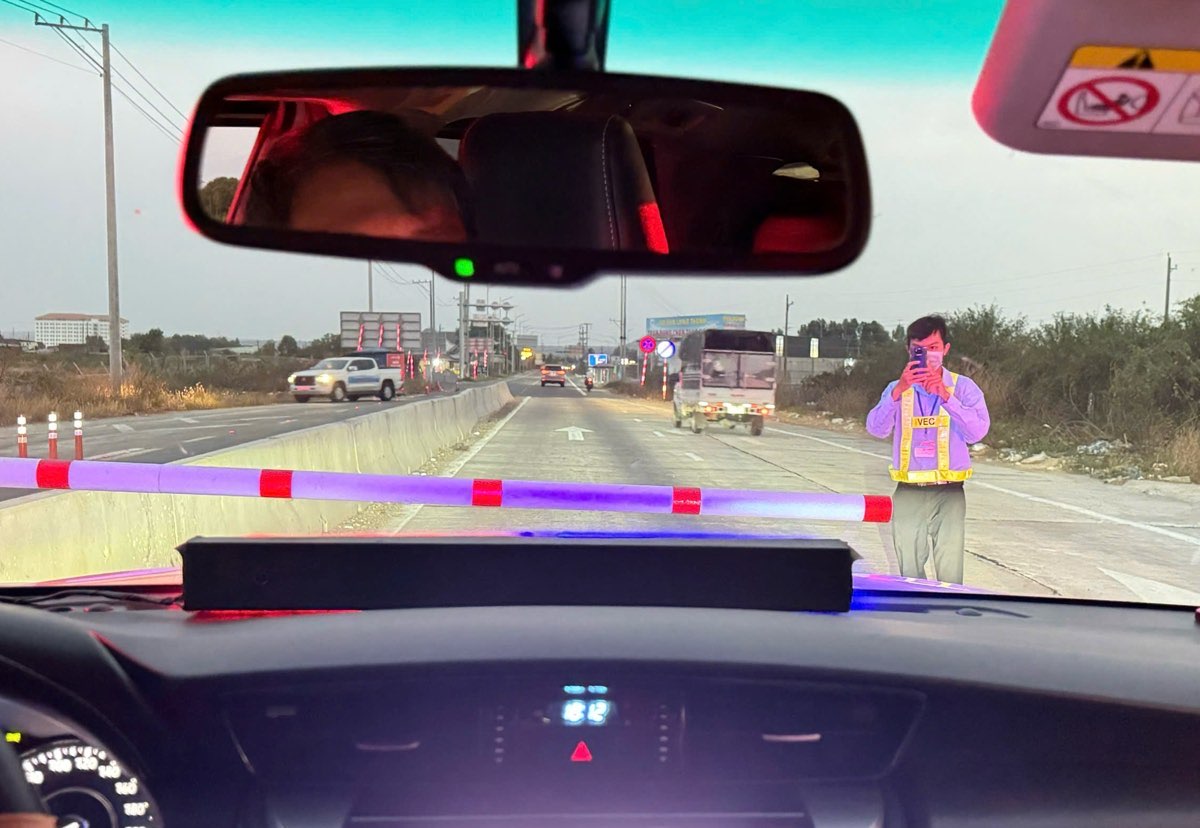 Nhân viên trạm thu phí dùng điện thoại chụp ảnh biển số xe do lỗi kỹ thuật của hệ thống thu phí không dừng. Ảnh: Duy Tuấn 