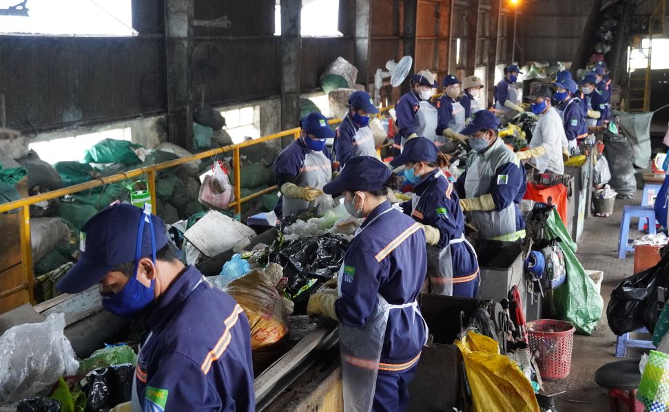 Những người công nhân lặng lẽ làm việc tại nhà máy xử lý rác. Ảnh: Phương Anh