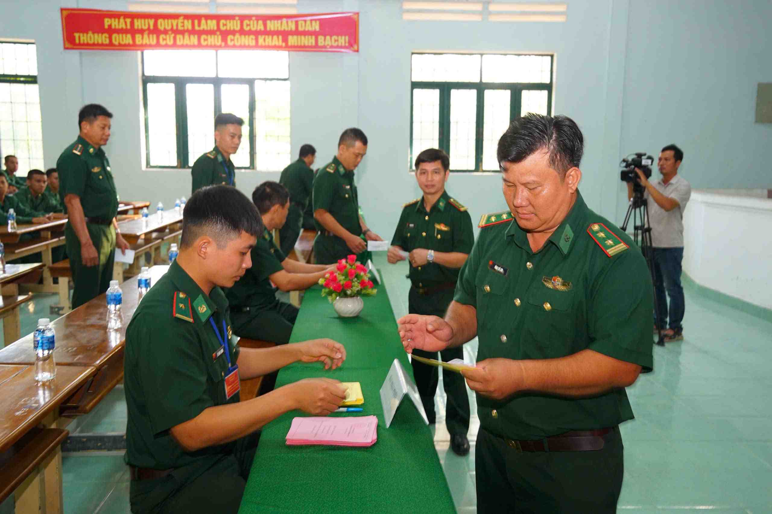 Các cử tri là cán bộ, chiến sĩ khu vực biên giới Lâm Đồng nhận phiếu cử tri thực hiện quyền và nghĩa vụ công dân. Ảnh: Nguyễn Nam 