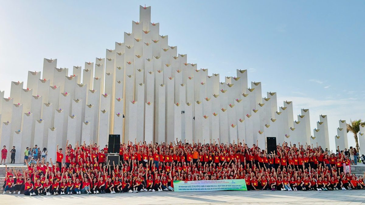 Tập thể lao động nữ chụp ảnh lưu niệm tại tháp Tam Thắng trong chương trình đồng diễn dân vũ. Ảnh: Thành An