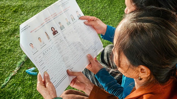 Bà con vạn chài nhận thẻ cử tri ngay trên sông trước ngày bầu cử. Ảnh: Hoàng Hà