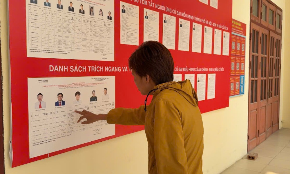 노동자들이 각급 인민의회 대표 및 2026-2031 임기 제16대 국회 대표 후보자 정보를 주의 깊게 읽고 있습니다. 사진: 퀸 치