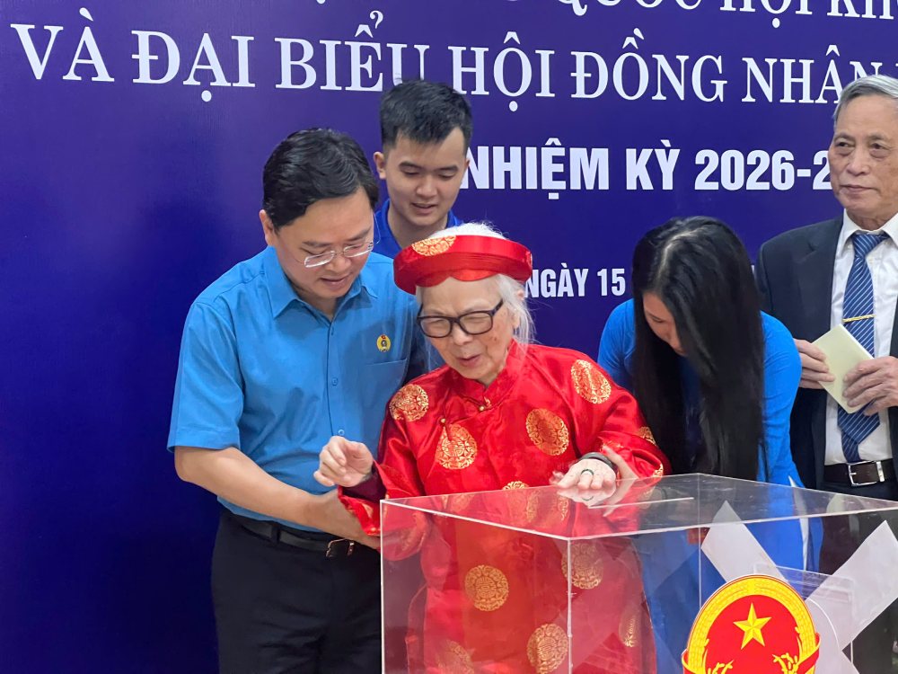 Ông Nguyễn Anh Tuấn - Ủy viên Trung ương Đảng, Ủy viên Ban Thường vụ Đảng ủy Mặt trận Tổ quốc, các đoàn thể Trung ương, Chủ tịch Tổng LĐLĐVN hỗ trợ bà cụ Hoàng Thị Liên (sinh năm 1931, cử tri cao tuổi nhất) trong quá trình bỏ phiếu. Ảnh: Thu Trà