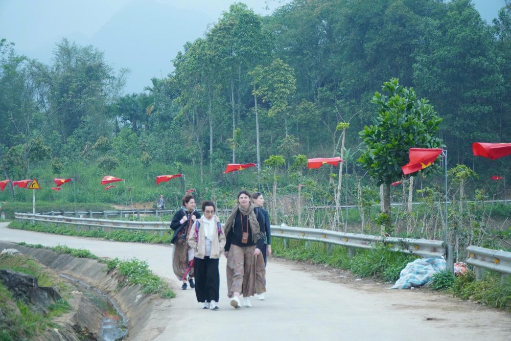 Du khách thích thú bước đi trên con đường chữ “S” rợp cở đỏ sao vàng. Ảnh: Quách Du