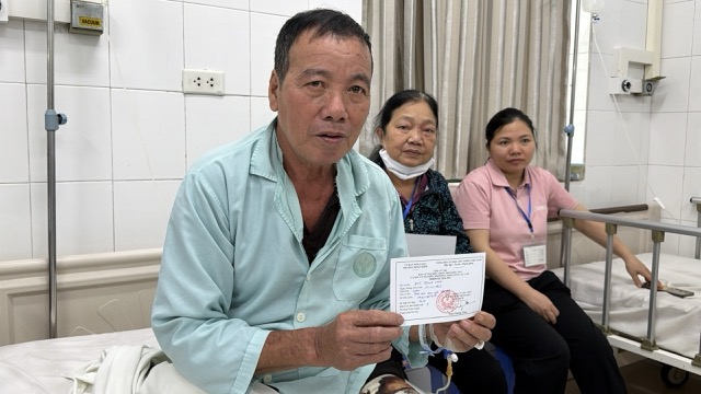 Ông Vinh và người nhà nhận phiếu cử tri tại Bệnh viện Hữu nghị Việt Đức. Ảnh: Thùy Linh