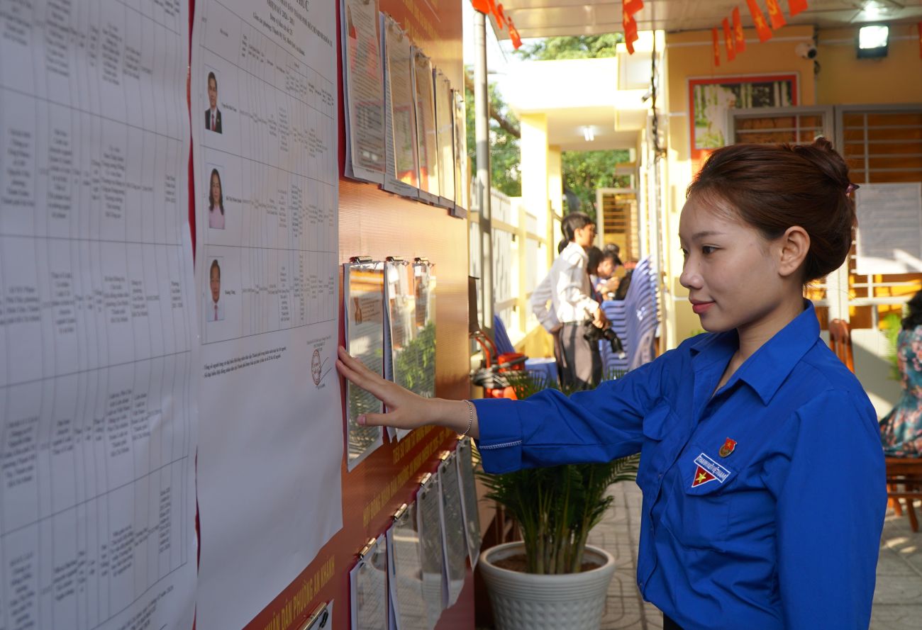 Bạn Minh Thư (phường An Khánh) coi tiểu sử tóm tắt của các ứng viên trước khi bỏ phiếu. Ảnh: Thanh Chân