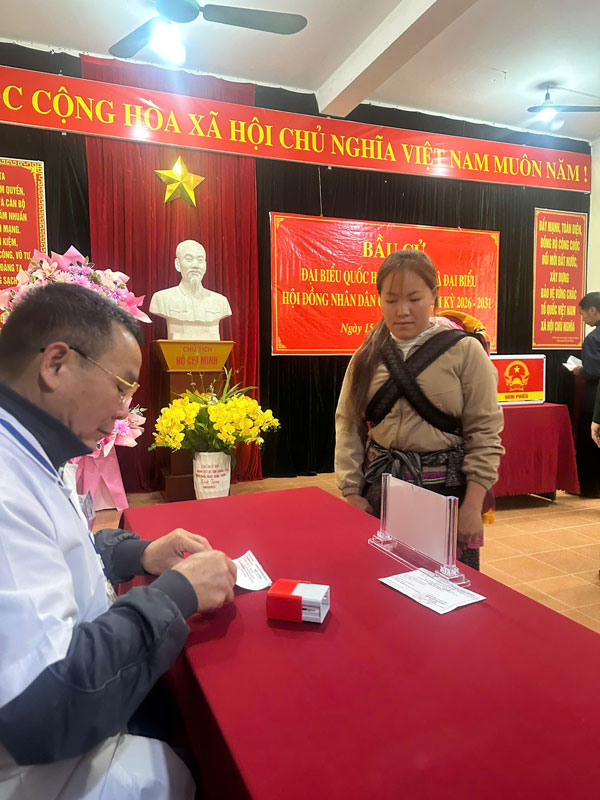 Người mẹ ở vùng biên Y Tý địu con đi bầu cử. Ảnh: Đinh Đại