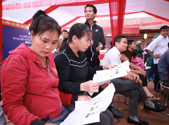 Trước giờ bầu cử, cử tri xã đảo Minh Châu, Hà Nội dành thời gian nghiên cứu về các đại biểu. Ảnh: Anh Tuấn