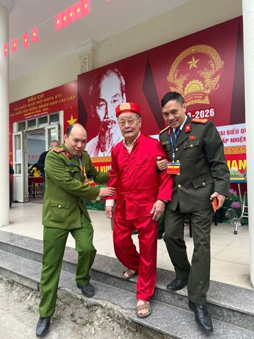 Chiến sĩ công an phường Thanh Liệt dìu các cụ già vào khu vực bỏ phiếu. Ảnh CAHN