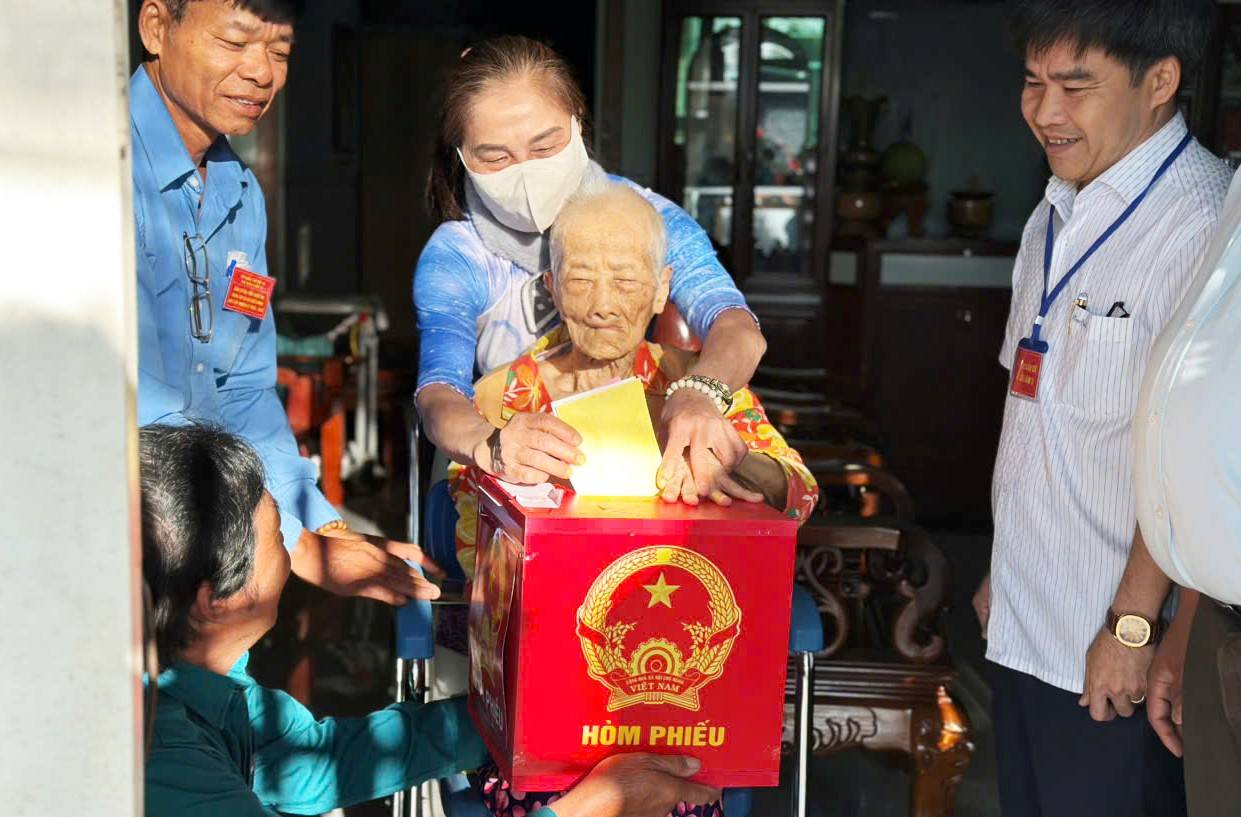 Mẹ Việt Nam anh hùng Bùi Thị Xê (95 tuổi, xã Bảo Lâm 3) được Tổ bầu cử mang thùng phiếu đến tận nhà bỏ phiếu thực hiện quyền, nghĩa vụ công dân với đất nước. Ảnh: Phúc Khánh