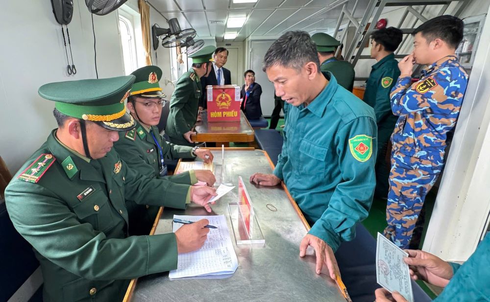 Hướng dẫn cử tri bỏ phiếu trên tàu. Ảnh: Duyên Duyên