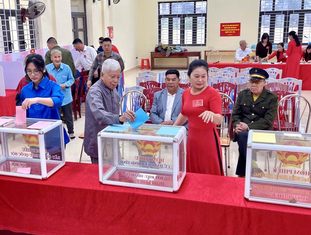 Cử tri Hà Văn Tứ (thứ 2 từ trái sang, 101 tuổi), trực tiếp dự lễ khai mạc và bỏ phiếu tại khu vực bỏ phiếu số 15, khu Đồng Giang, phường Hoành Bồ. Ảnh: Hồng Phương