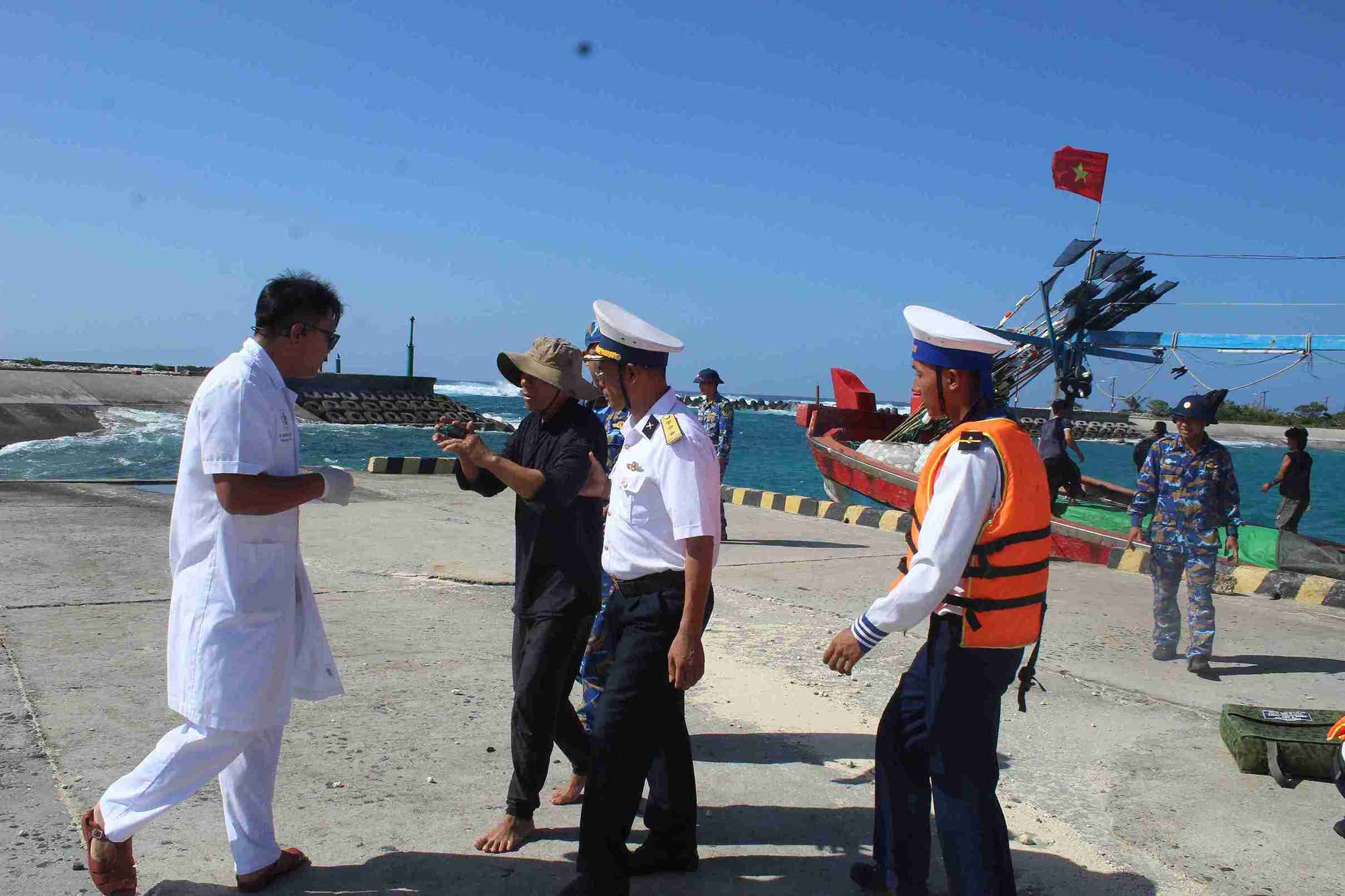 Bác sĩ thăm hỏi ngư dân gặp nạn tại cầu cảng. Ảnh: Sơn Ca