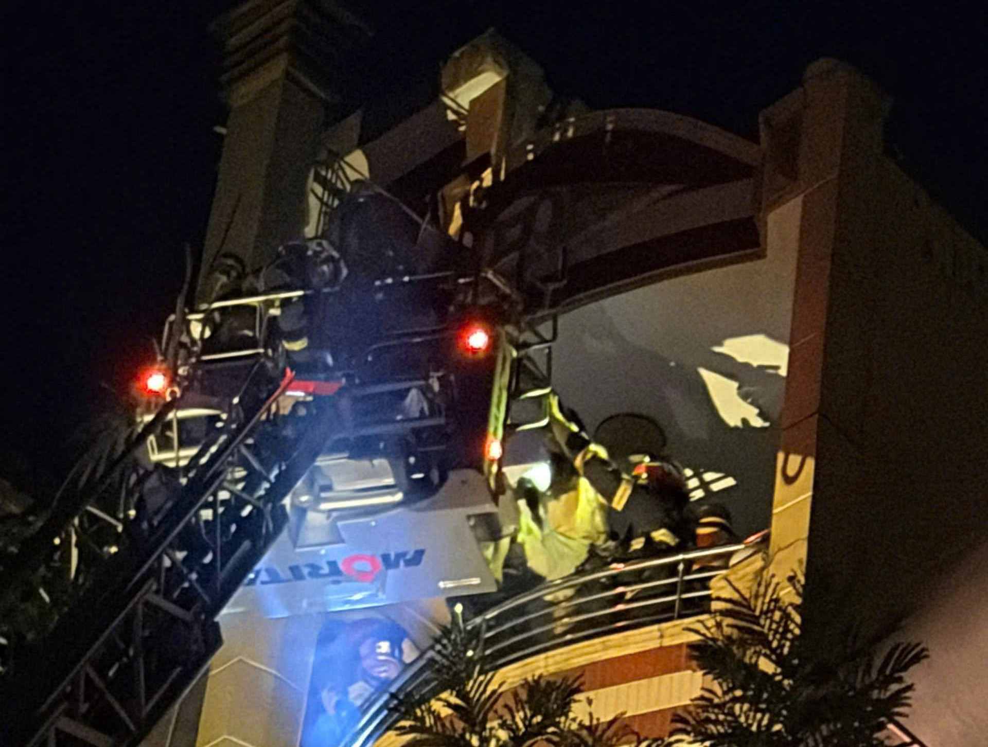 Lực lượng chữa cháy nỗ lực đưa người mắc kẹt bên trong nhà ra bên ngoài. Ảnh: PC07