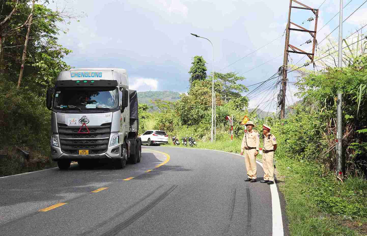 Lực lượng CSGT Trạm Mađaguôi chốt chặn, điều tiết giao thông 2 đầu đèo Bảo Lộc bảo đảm an toàn để xử lý khối đá. Ảnh: Phúc Khánh 