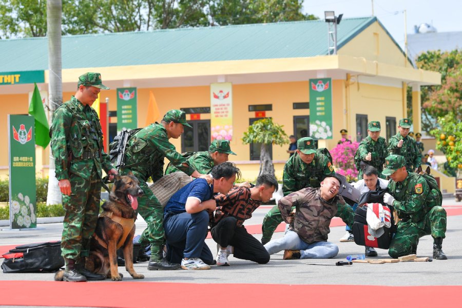 Chiến sĩ Đồn Biên phòng Trà Cổ diễn tập tình huống dùng chó nghiệp vụ kiểm tra, bắt nghi phạm vận chuyển hàng cấm. Ảnh: Ái Vân