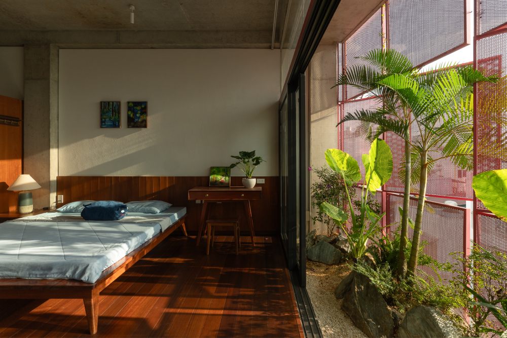 Nội thất làm từ gỗ tự nhiên được giữ trạng thái “sống” - có khoảng hở cong vênh theo khí hậu. Cây xanh đan cài xen lẫn vào các khoảng trống làm mát dịu không gian, tăng sự riêng tư và gần gũi với thiên nhiên.