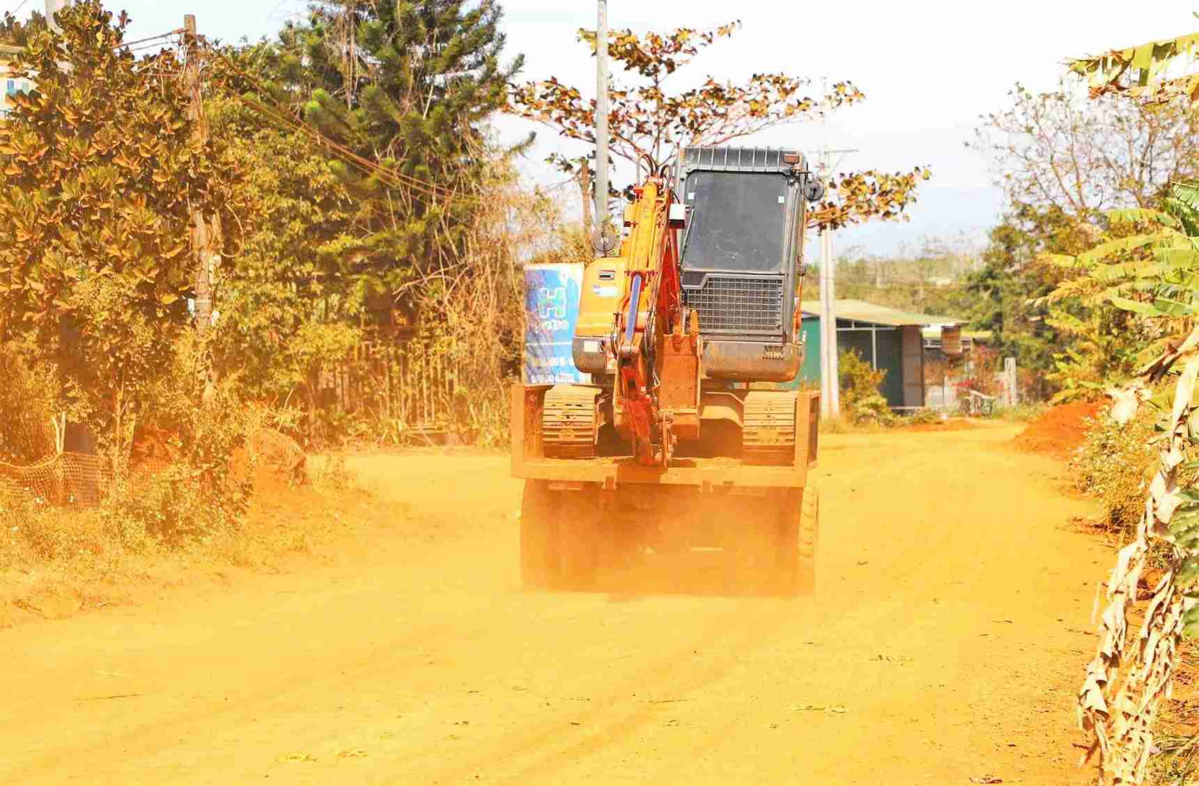 Mỗi khi phương tiện giao thông di chuyển qua, bụi đỏ bay mù mịt gây ảnh hưởng nghiêm trọng đến đời sống người dân. Ảnh: Phúc Khánh 