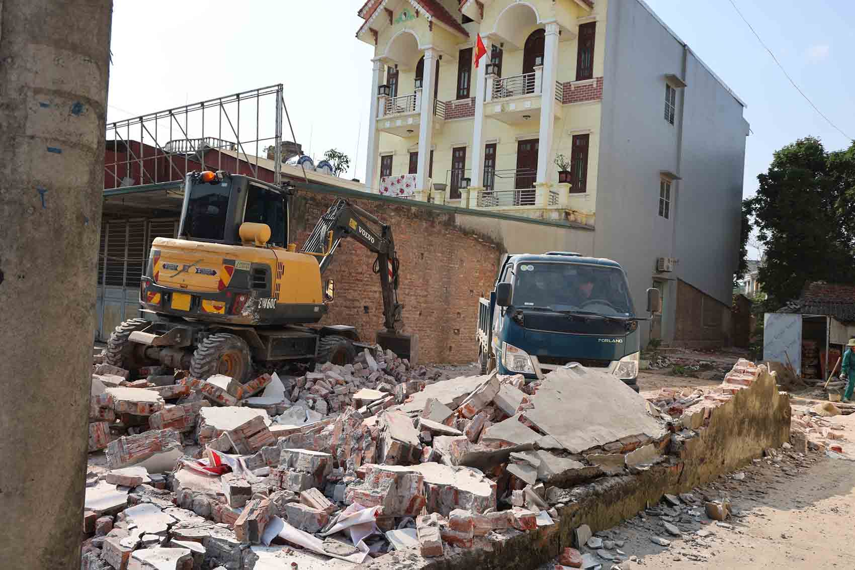 ハノイ市バーラー-スアンマイ区間の国道6号線改修・改良プロジェクトの土地収用範囲内の施設を破壊する機械。写真:フーギアコミューンTTĐT