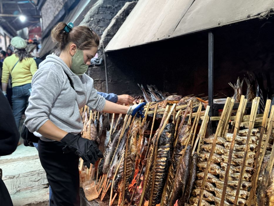 Người dân nướng cá phục vụ nhu cầu của du khách khi đến đền. Ảnh: Hải Đăng