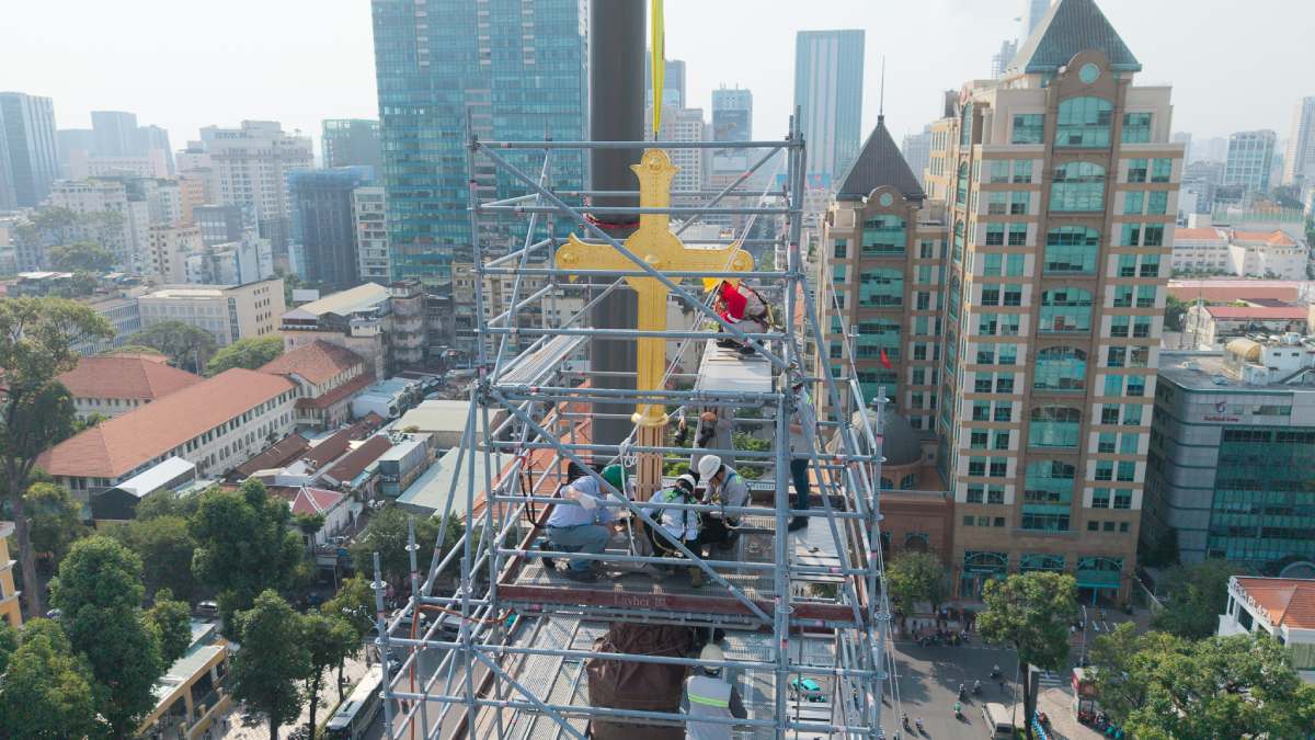 The moment Notre Dame Cathedral lifts two gold-plated crosses to the top of the nearly 60m high tower. Photo: Anh Tu.