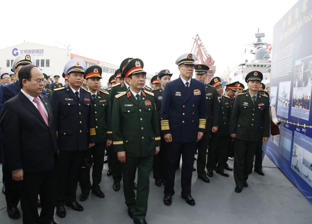 Hai Bộ trưởng tham quan khu trưng bày hình ảnh về các chuyến tuần tra liên hợp trước đây giữa Hải quân hai nước. Ảnh: Hoàng Diệu