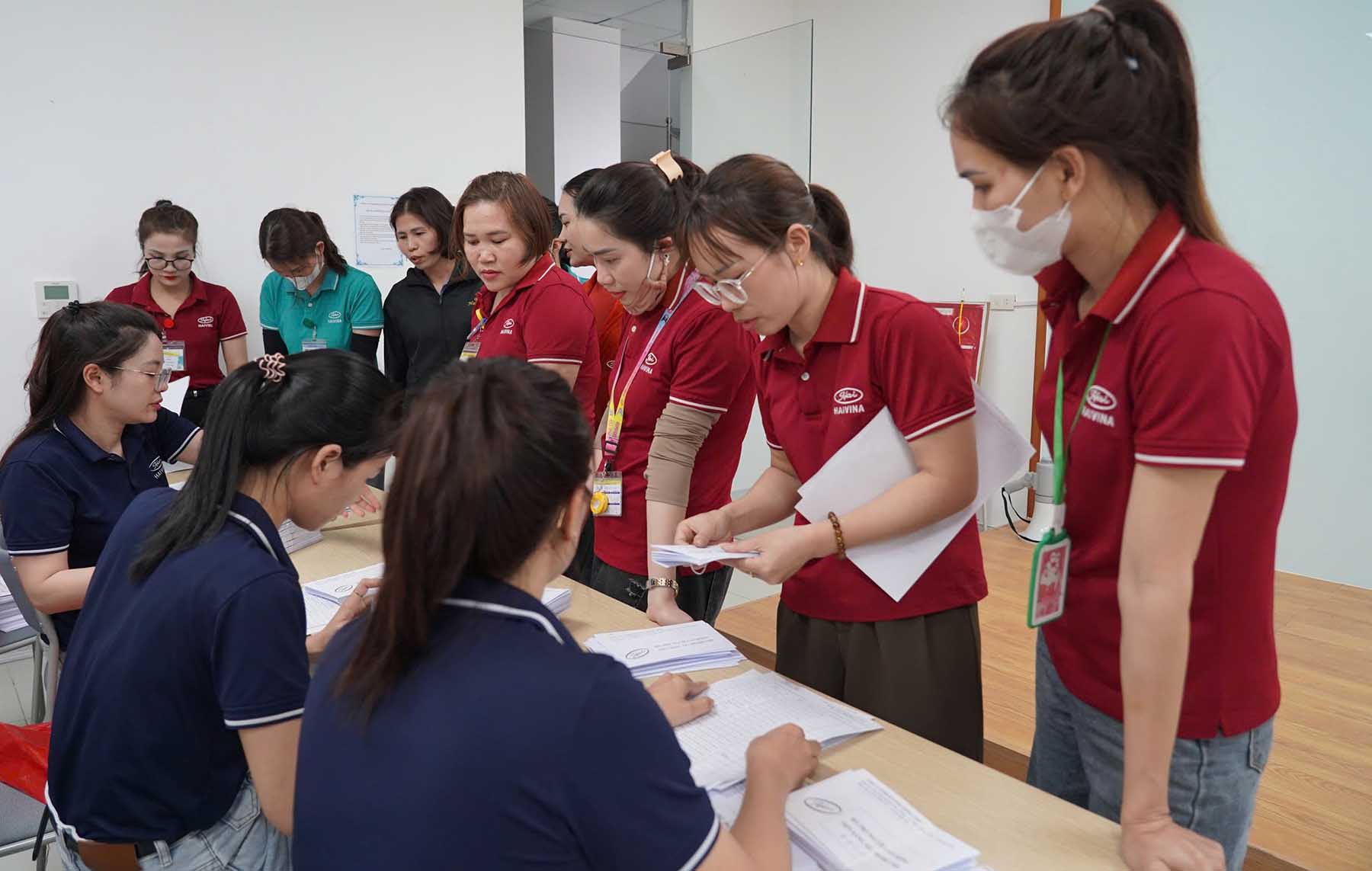 Công nhân nhận tiền hỗ trợ  để giảm bớt khó khăn khi giá xăng tăng cao. Ảnh: Trần Tuấn