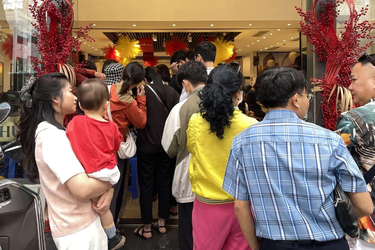 Người dân xếp hàng từ bên trong quầy giao dịch nối ra phía bên ngoài cửa hàng. Ảnh: Hạ Linh