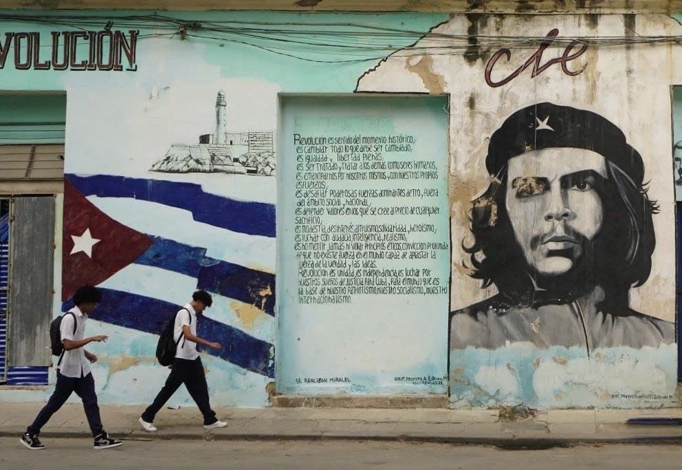 Two young people walk across a wall with portraits of Che Guevara in Havana, Cuba, January 26, 2026. Photo: Xinhua