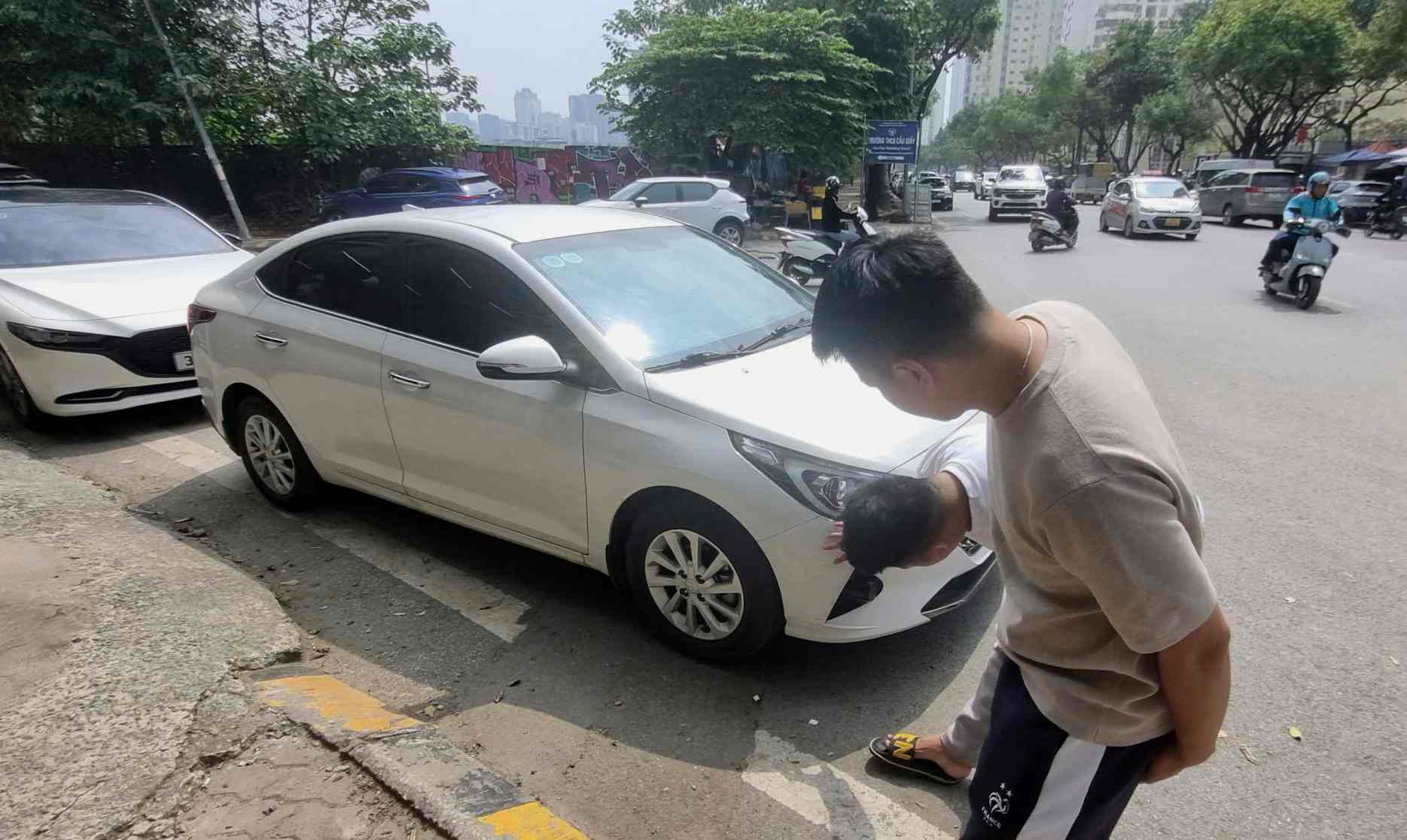 Customers looking at cars at a used car dealership in Hanoi. Photo: To The