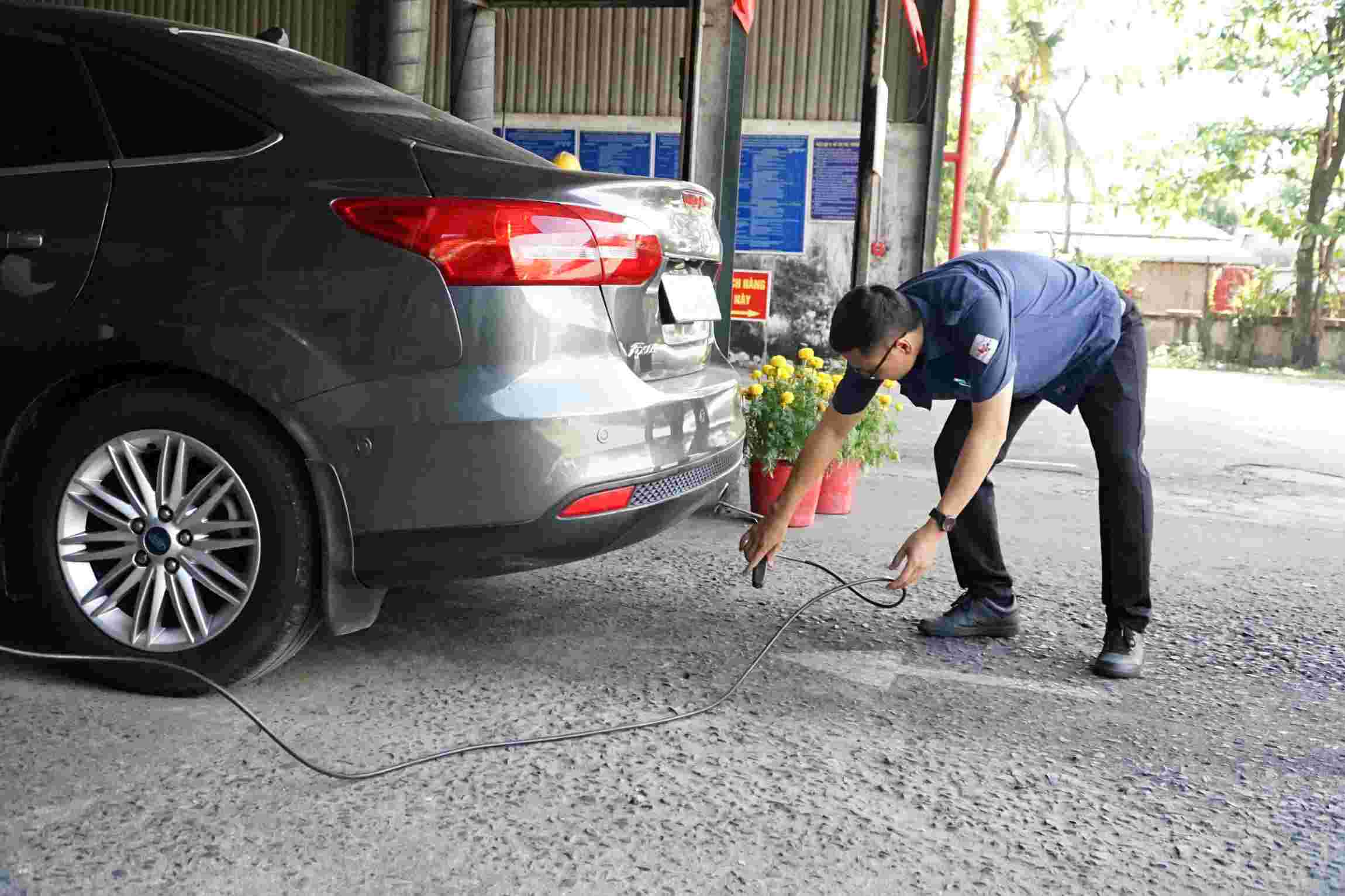 Kỹ thuật viên Trung tâm Đăng kiểm 50-05V đo khí thải ôtô theo quy trình mới. Ảnh: Anh Tú